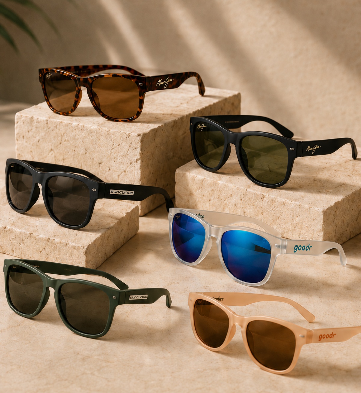 Maui Jim, Smith, Suncloud and Goodr sunglasses arranged on stone blocks