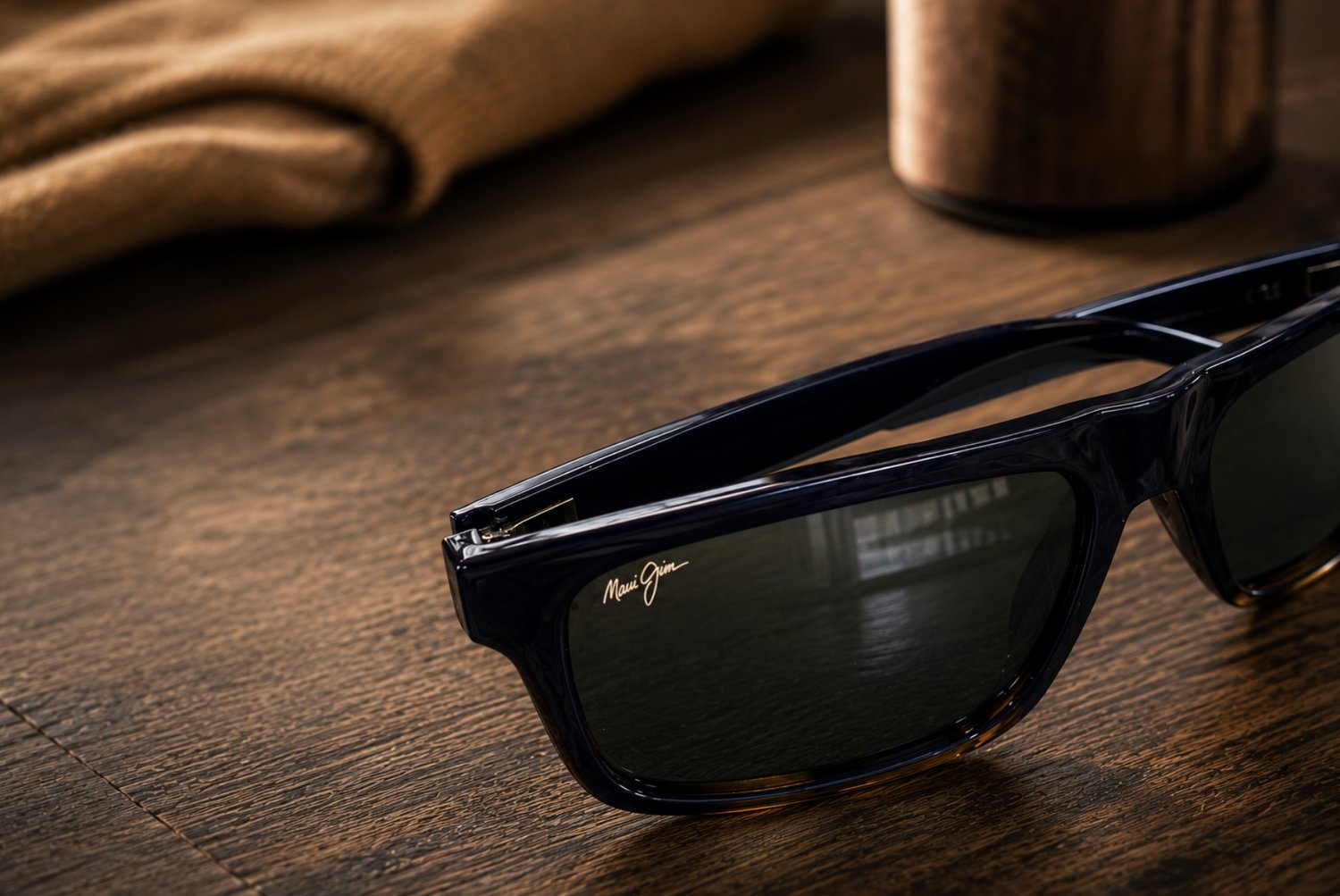 A pair of Maui Jim polarized sunglasses resting on a wooden table